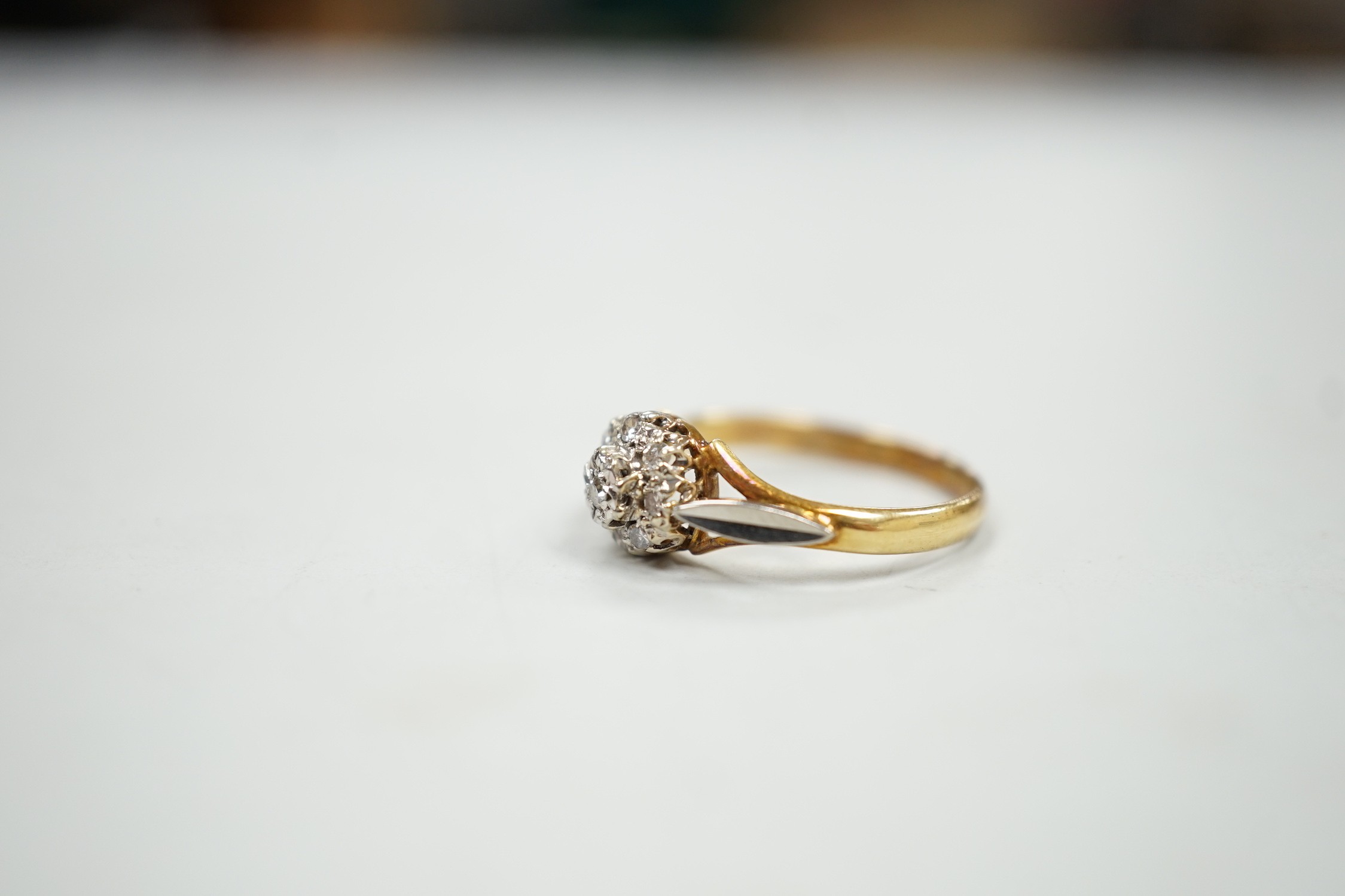 An 18ct and diamond cluster set ring, size K, gross weight 2.4 grams.